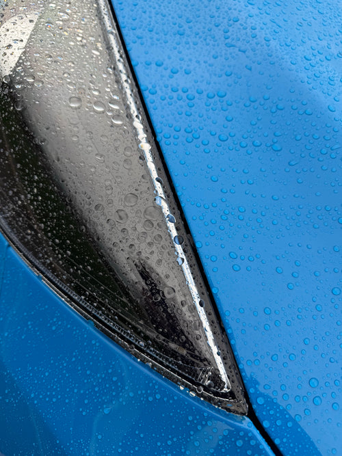 Water beading on a blue car bonnet and headlight coated with Pure Gloss Pro 9H